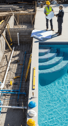 Yeni inşa edilmiş modern bir yüzme havuzu, planlama ve yapım sürecinin önemini vurgulayan detaylarla çevrili. Havuzun temiz suyu, bakımlı peyzajı ve güneşli bir ortam, havuz yapımı kararı öncesi araştırılması gerekenleri yansıtıyor.